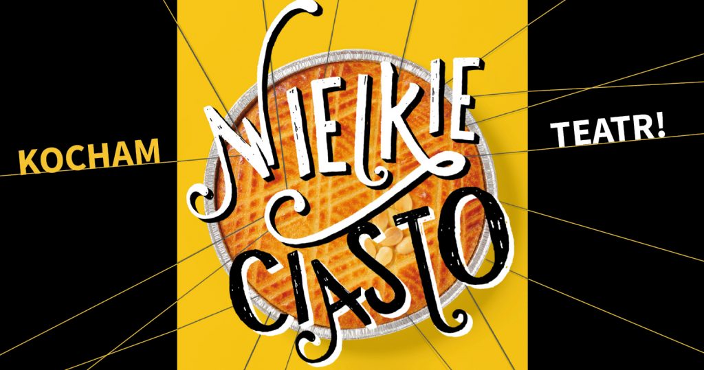 Zdjęcie okrągłego ciasta zrobione od góry. Ciasto na żółtym tle. Wokół napis: Kocham teatr! Wielkie ciasto