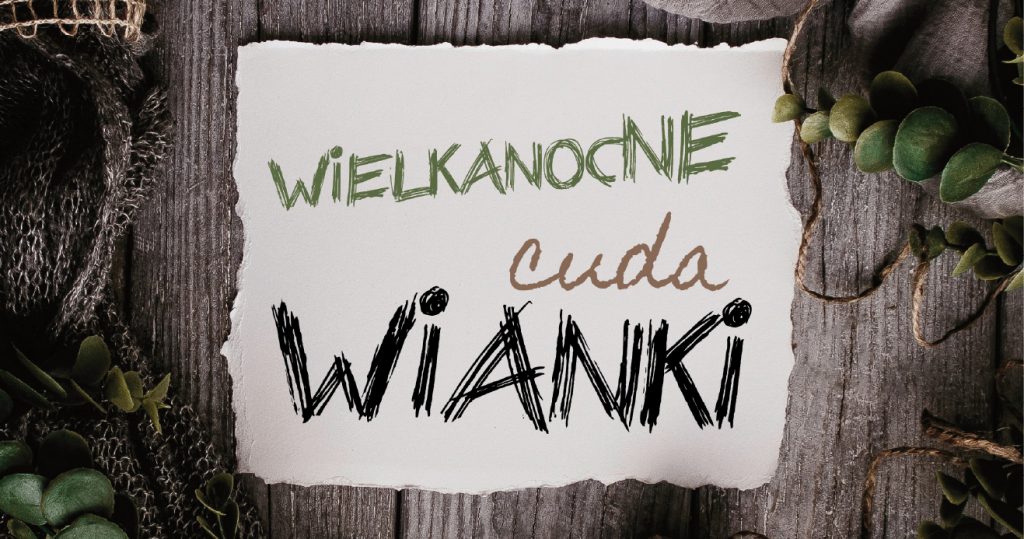 Napis na białej postrzępionej na rogach kartce: Wielkanocne cuda wianki. Kartka umieszczona na tle starych desek, wokół liście i kawałki sznurka i worka parcianego