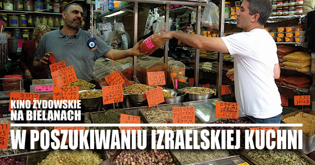 Zdjęcie dwóch mężczyzn na targu - jeden jest sprzedawcą na stoisku z sypkimi produktami. Drugi kosztuje z podanego mu przez sprzedawcę słoika. Na dole napis: Kino żydowskie na Bielanach. W poszukiwaniu izraelskiej kuchni