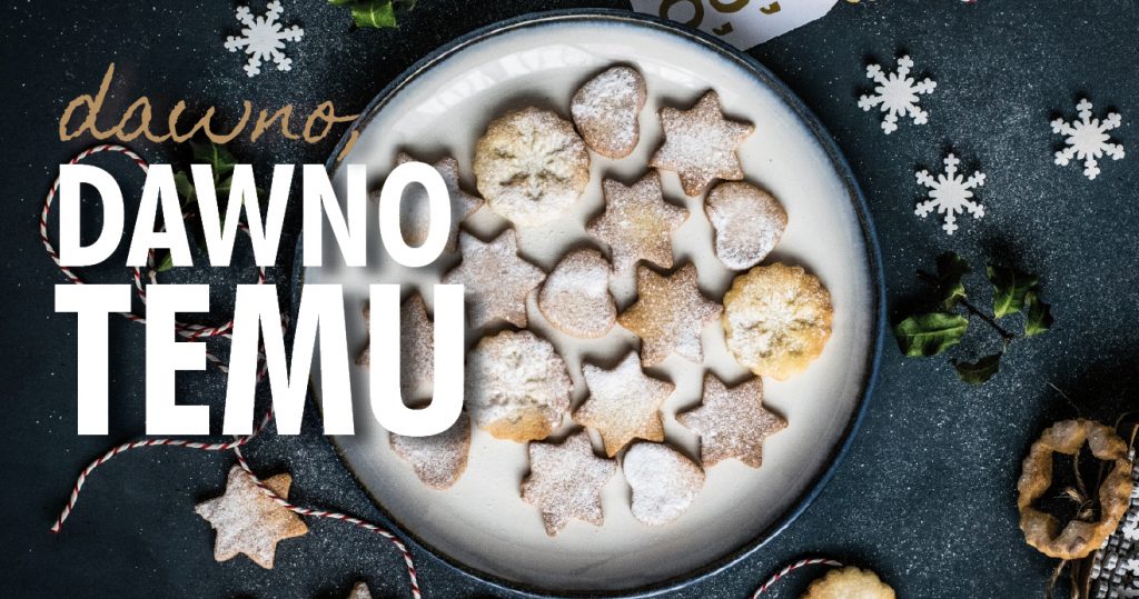 Zdjęcie talerza ze świątecznymi ciasteczkami, oprószonymi cukrem pudrem, wokół talerza delikatne świąteczne ozdoby. Po lewej napis: Dawno, dawno temu