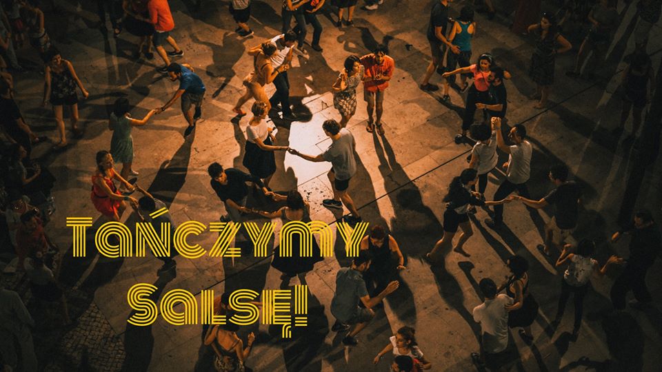Zrobione od góry zdjęcie parkietu, na którym kilkanaście par tańczy w delikatnym świetle