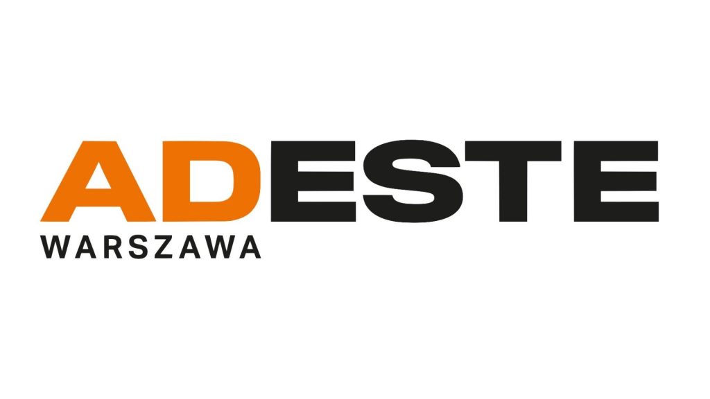 Napis: Adeste Warszawa (dwie pierwsze litery pomarańczowe, pozostałe czarne)