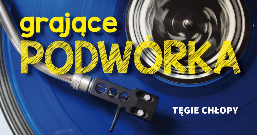 Zdjęcie granatowej płyty w gramofonie z igłą zrobione od góry. Po środku duży żólty napis: Grające Podwórka, w prawym dolnym rogu napis: Tęgie Chłopy