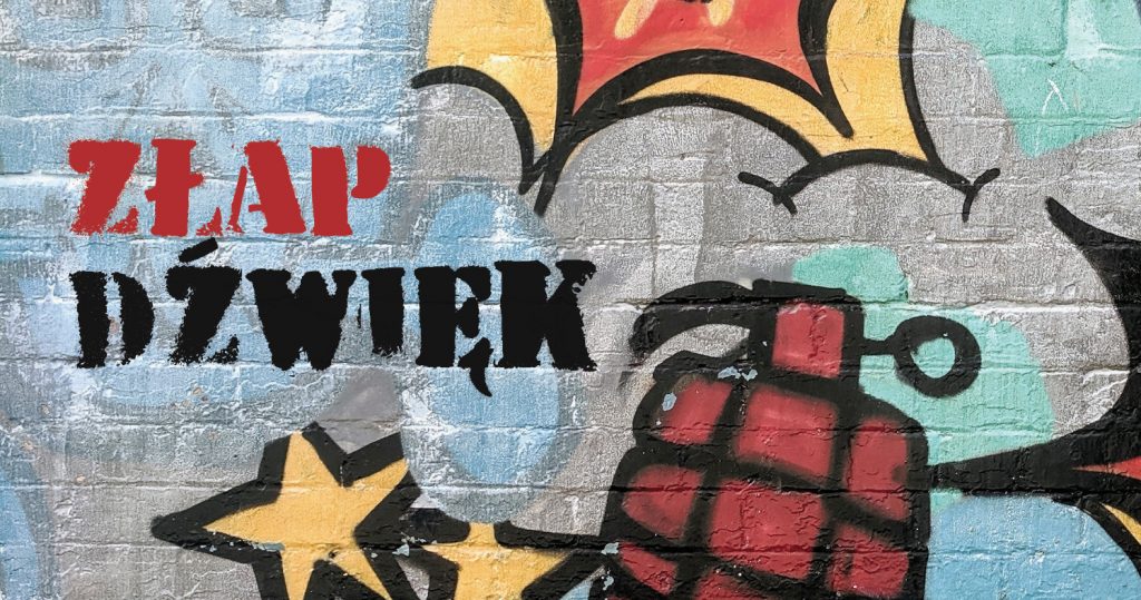 Na zdjęciu znajduje się fragment grafitti. Widać na nim wybuch oraz kawałek granatu. Widnieje napis: Złap dźwięk
