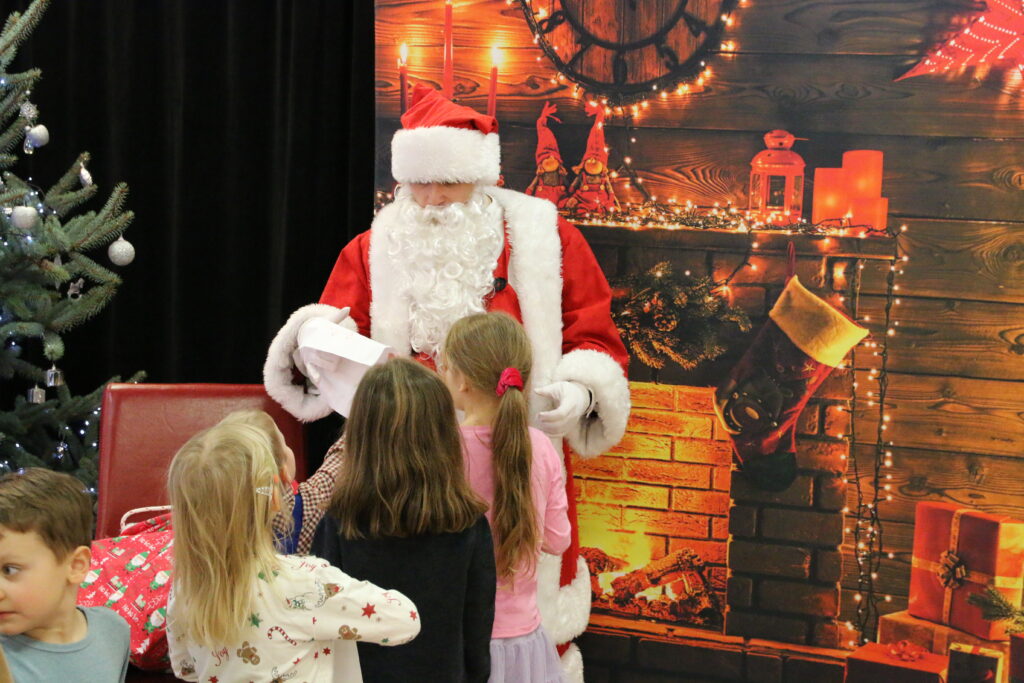święty Mikołaj rozdający dzieciom prezenty